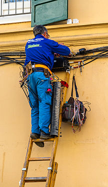 Fernmeldehandwerker in Palma (Mallorca) bei der Arbeit (Kabelverlegung auf der Außenwand) Telecommunications worker in Palma (Majorca) at work (cable transfer on the outer wall)