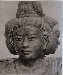 Portrait of a sculpture with three faces pointing to the front and both sides.