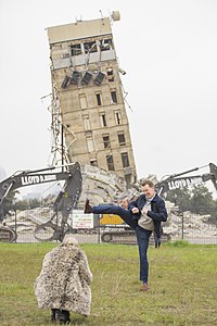 A man posing with the Leaning Tower of Dallas