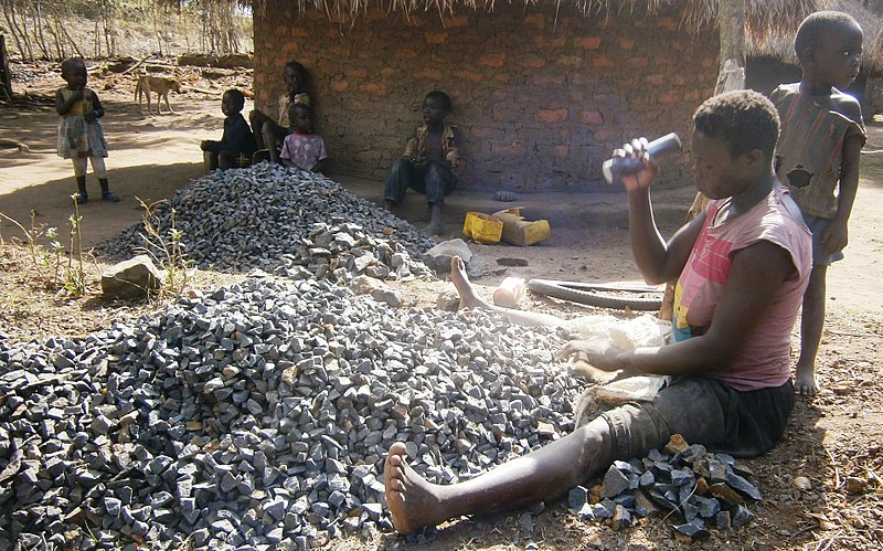 File:A woman in crushes stones to be used for construction. She uses this as aher source of income to pay her children in school, pay medical bills and for home sustainability. PHOTO BY FELIX WAROM OKELLO.jpg