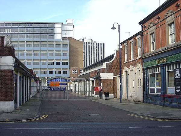 View along Avenue 'B' through the old fruit and veg wholesale market units, with iQ student accommodation block across the end