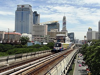 A BTS train departs from Ratchadamri station, towards Siam station. BTS Skytrain in Bangkok (7997069605).jpg