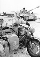 Dispatch rider from a heavy tank battalion ... as a Tiger I passes by, February 1944 (description abbreviated from same image in Nash, p. 238)