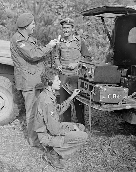 Image: CBC war correspondents Normand Eaves, holding the microphone, and Norman Mc Bain...   Le correspondant de guerre Normand Eaves, au micro, et No