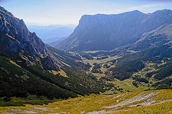 Blick über die Fölzalm nach Südwesten. Rechte Bildhälfte beschattet die Nordostwand von Fölzstein (Kante Links) und Fölzkogel („Pyramide“ rechts).