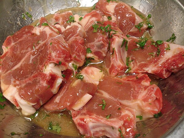 Raw goat chops in an apricot glaze about to be cooked