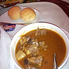 Goat meat pepper soup served with bread.jpg