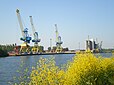 Sur la rive droite (Est) du Canal de Caen à la mer, le quai de la ZI Caen-Canal, avec ses grues et les silos à blé d'Agrial.