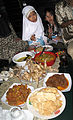 Uma família indonésia celebrando o lebaran com vários pratos culinários específicos para este feriado