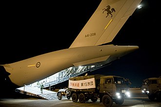 A Japan Ground Self-Defense Force truck driving from A41-208 at Yokota Air Base after being flown from Okinawa JGSDF truck being unloaded from a RAAF C-17.JPG