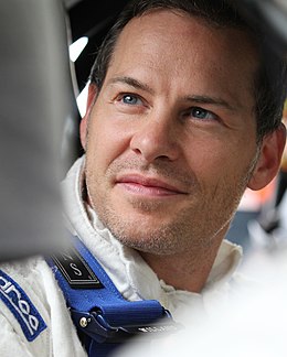 Head shot of a man in his late thirties. He has short, brown hair and is staring to his right.