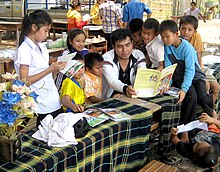 A volunteer reads aloud to children in Laos. Khamla Panyasouk of Big Brother Mouse reads to children.jpg
