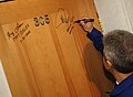 Pontes signing the Baikonur Cosmodrome checkout hotel room, an Astronaut/Cosmonaut tradition