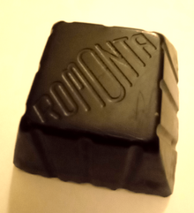 A block of montan wax embossed with the mark of ROMONTA GmbH Montanwax.png