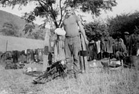 A mustering camp with a freshly baked damper. The pack saddles and oilskin coats are drying on the fence. Mustering camp.jpg