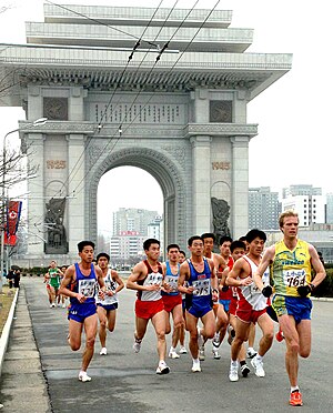 Participants in the 2012 Pyongyang Marathon running past the Arch of Triumph.jpg