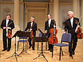 Image 23A modern string quartet. In the 2000s, string quartets from the Classical era are the core of the chamber music literature. From left to right: violin 1, violin 2, cello, viola (from Classical period (music))