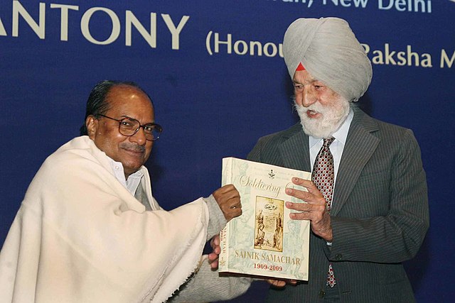 AK Antony presenting a copy of 'Sainik Samachar' to Marshal of the Indian Air Force Arjan Singh to mark the centenary celebrations of the Armed Forces