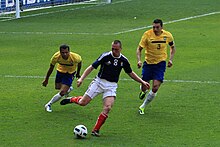 Scott Brown with the Scotland national football team against Brazil, 2011 Alves, Scott Bown and Lucio (5575158739).jpg