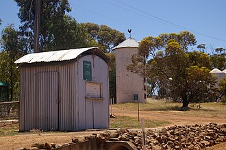 The heritage listed weighbridge c. 1936 in foreground with the heritage listed c. 1927 silo behind Avondale ag rs gnangarra 02.JPG