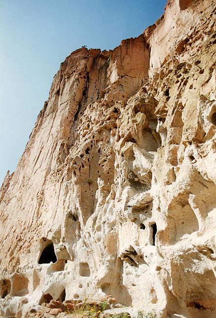 Cliff face of welded tuff pockmarked with holes — some natural, some human-made from Bandelier National Monument, New Mexico