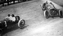 Barney Oldfield (left) racing a car on a board track in 1915 Barneyboards17March1915.jpg