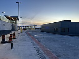 Bus platform in the bus loop at Bowesville, facing West towards the station entrance. Staff facilities building is shown on the right. Bowesville bus loop.jpg