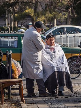 Open haircut on the street in Beijing