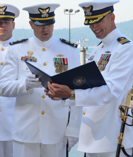 A Coast Guard chief warrant officer (CWO2, left) and an officer (commander, O-5, right) wearing Full Dress Whites