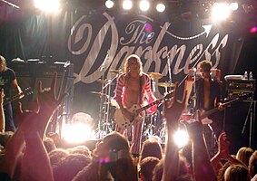 The Darkness performing at the Gaelic Club, Sydney, Australia in January 2004. From left to right: Dan Hawkins, Justin Hawkins, Ed Graham (hidden) and Frankie Poullain.