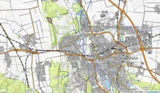 Die topographische Karte zeigt mit Höhenlinien bewaldete und unbewaldete Gebiete, Berge mit Höhenangaben sowie Verkehrswege