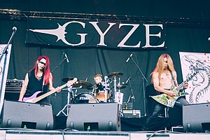 three Japanese male musicians perform on stage of an open air festival