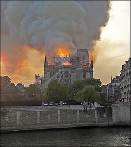 האש אוחזת בגג הקתדרלה, סמוך למקום צריח המצלב (19:53). מבט מאיל סן לואי, מעבר לנהר