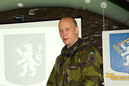 Commander Karl Engelbrektson next to coats of arms of the Nordic Battlegroup on 15 March 2007