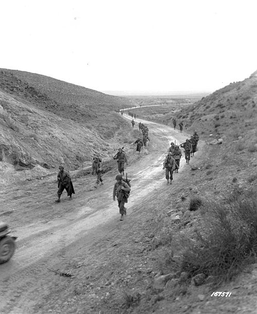 Men of the 2nd Battalion, 16th Infantry Regiment of the U.S. 1st Infantry Division march through the Kasserine Pass and on to Kasserine and Farriana, 