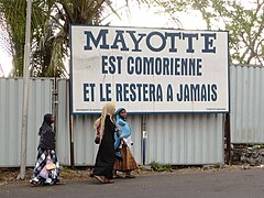 Les revendications comoriennes sur Mayotte (ici sur un panneau à Moroni[17]) lui donnent sa devise « Ra Hachiri » (« Nous somme vigilants ») apparaissant sous l'écu.