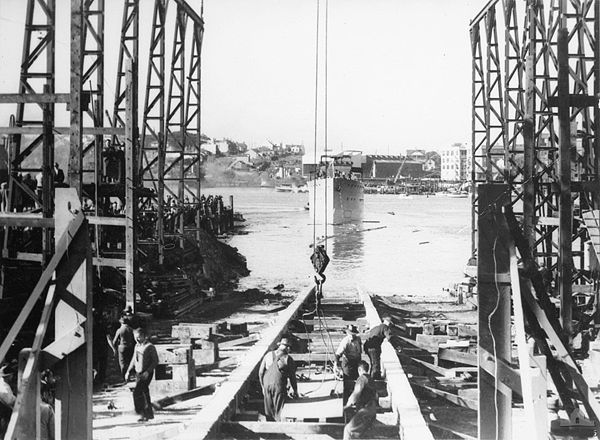 Minutes after the launch of HMAS Deloraine at Mort's Dock & Engineering Company workers begin preparations to lay down the next vessel.