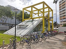 Photograph of station entrance encased in a yellow cubic structure