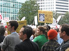 Marchers outside City Hall with sign remembering Helen Hill