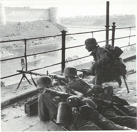 Soldiers defending the Estonian bank of the Narva River, with the fortress of Ivangorod on the opposite side.