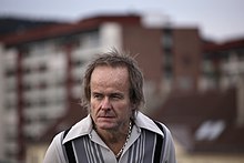 Норвегиялық автор және музыкант Сверре Кнудсеннің портреті. Фонда Ослодағы Sandaker Senter тұр.