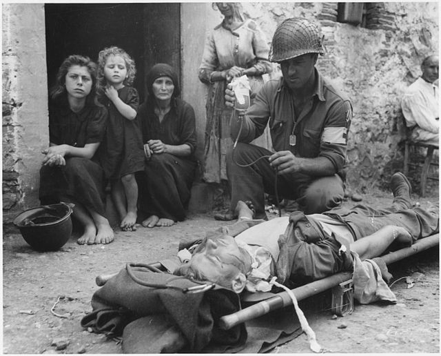 Private Roy W. Humphrey is being given blood plasma after he was wounded by shrapnel in Sicily in August 1943.