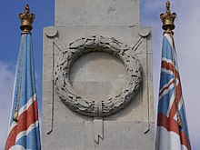 A sculpted laurel wreath on the front of an obelisk