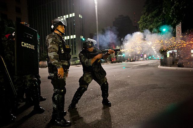 A Military Police of São Paulo State officer firing a grenade launcher loaded with tear gas