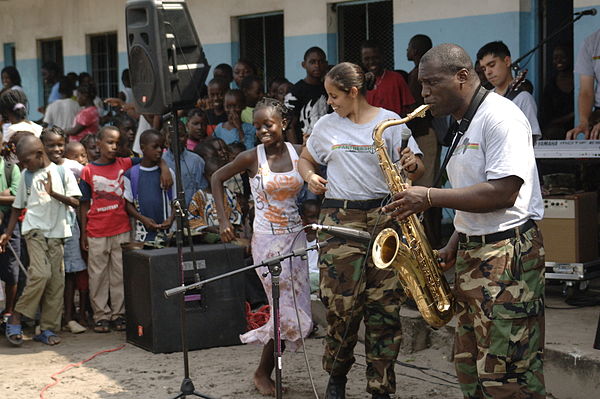 A student from Belise Elementary School dances to music from members of the Africa Partnership Station band