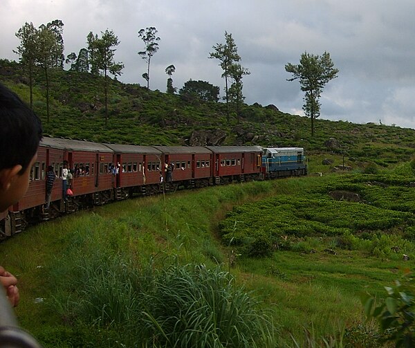 An express train, the Udarata Menike (M6 locomotives), runs through the scenic Sri Lankan hill country