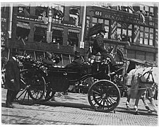 Theodore Roosevelt's coach passing the Lowman Building, May 23, 1903.