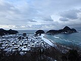 積雪に覆われた竹野浜海水浴場と猫崎半島（2021年1月）