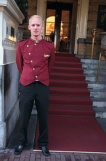 Bellhop standing in front of a hotel Bellhop standing.jpg