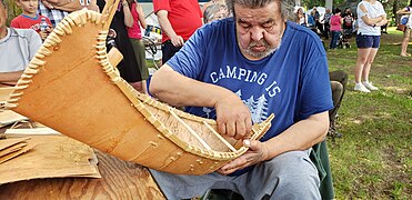 An Atikamekw artisan making a miniature canoe